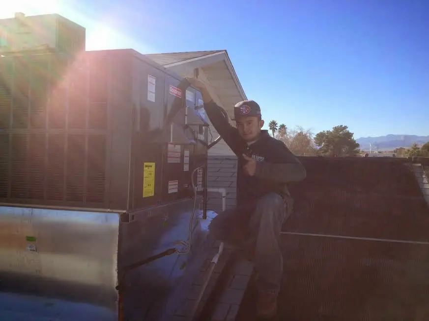HVAC technician performing AC Tune-Up on a rooftop unit in Birmingham